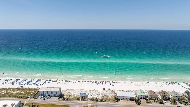 A beach with a parking lot and buildings in the foreground. - Walk to Private Beach+Free golf cart+Private Heated Pool+Pet Friendly (Destin)