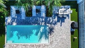 A rooftop pool with lounge chairs, a small table, and a barbecue area. - Walk to Private Beach+Free golf cart+Private Heated Pool+Pet Friendly (Destin)