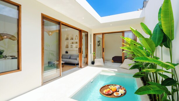 A modern house with a swimming pool, sliding glass doors, and a dining area with a breakfast setup. - Villa Joba by Pertama Stay (Canggu)