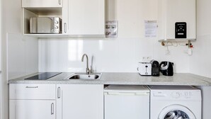 A compact kitchen with a sink, toaster, kettle, and dishwasher. - TheBlueStay 136 - Beautiful Duplex Apartment (Paris)