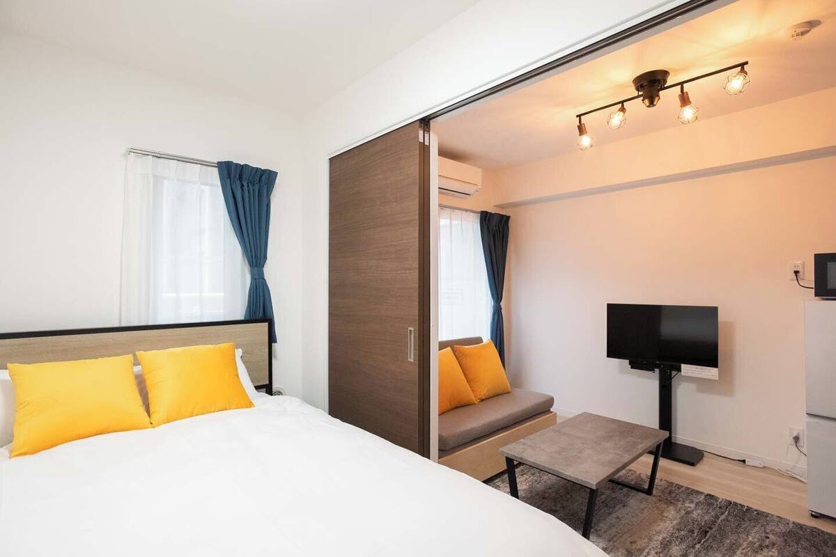 A hotel room with a bed, a sofa, a TV, and a desk.
