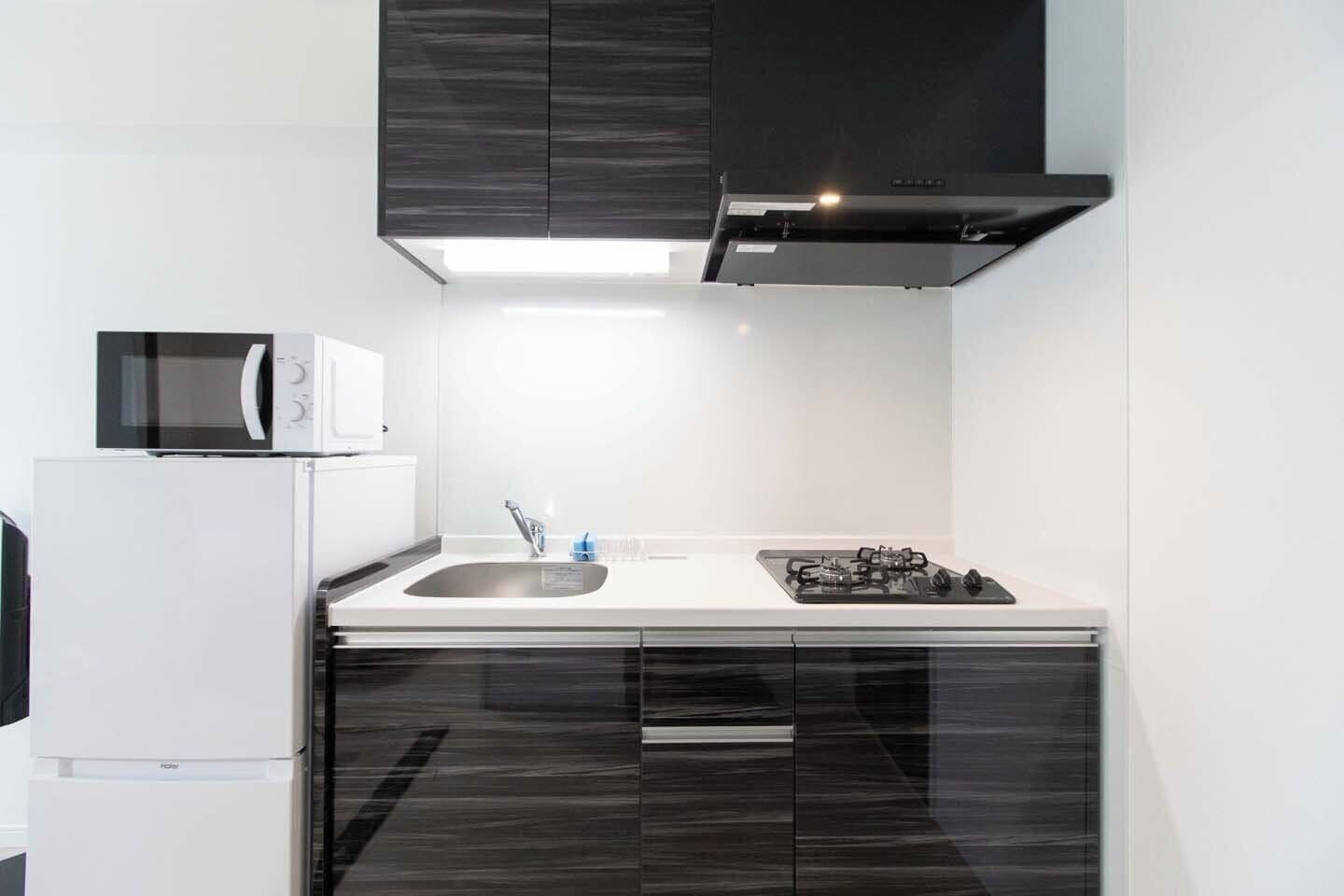 A modern kitchen with a microwave, sink, and stove.