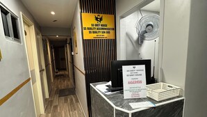 Ein Empfangsschalter mit Schildern für SS Grey House, SS Quality Accommodation, SS Quality SDN BHD und Kontaktinformationen.