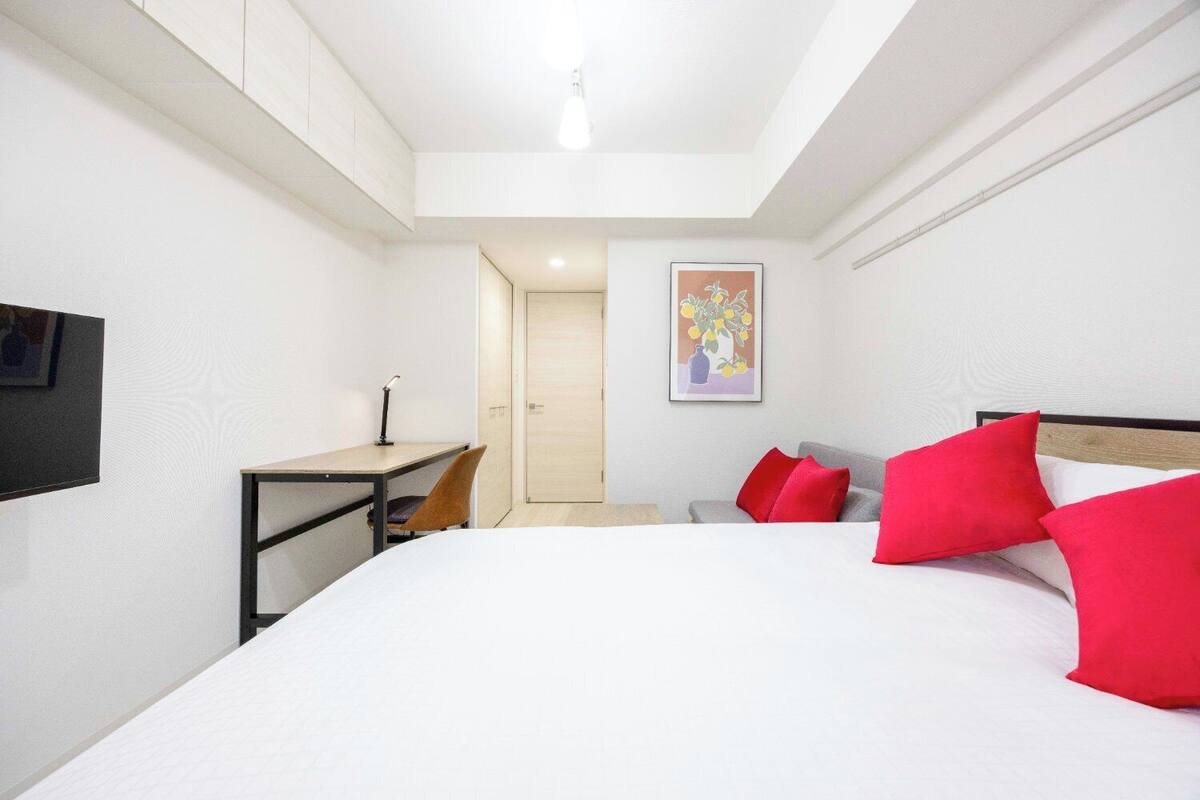 Ein Hotelzimmer mit Bett, Schreibtisch, Stuhl und einer Tür.