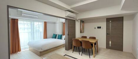 Een moderne hotelkamer met een bed, een bureau en een eettafel.