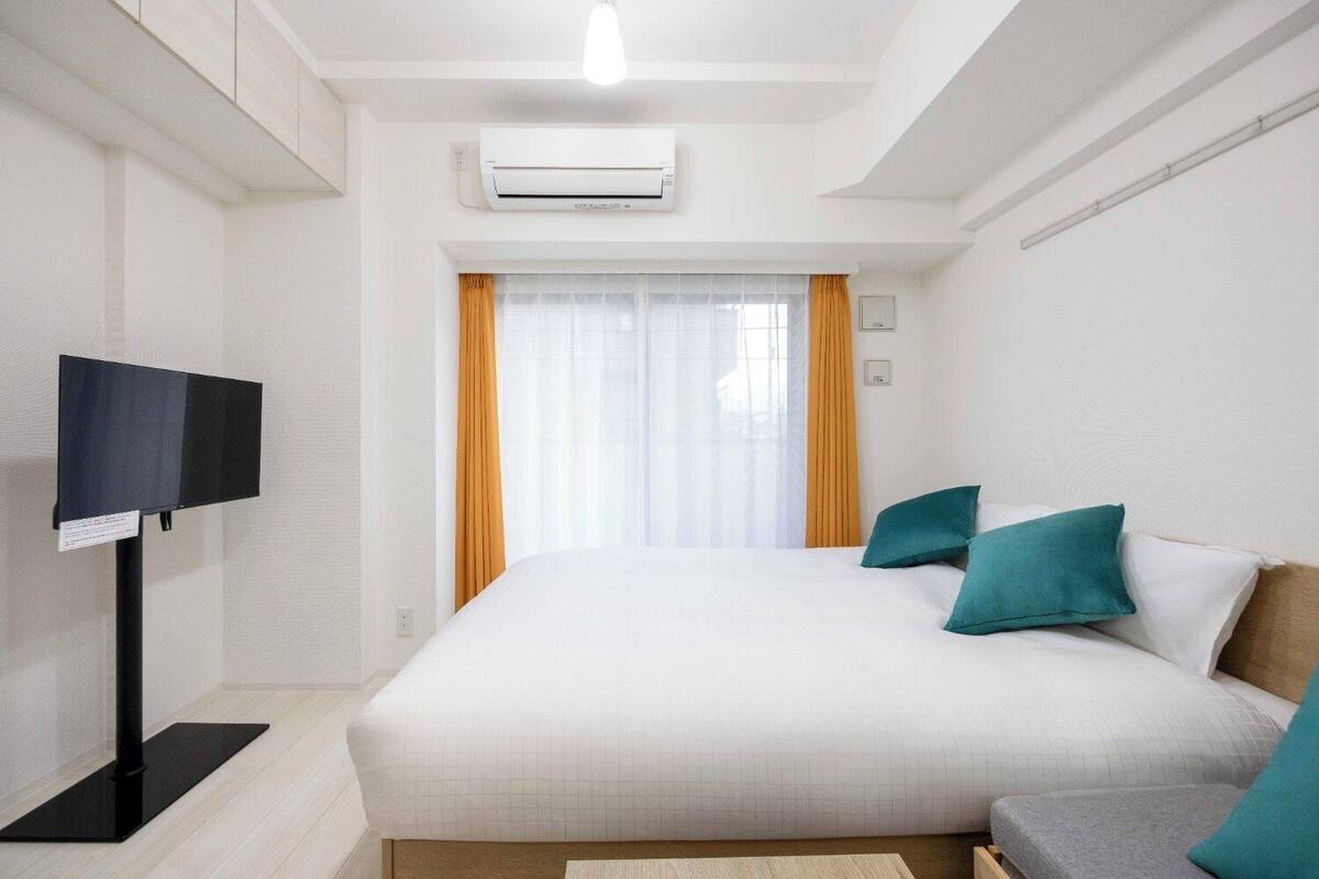 Ein Hotelzimmer mit einem Bett, einem Fernseher und einer Klimaanlage.