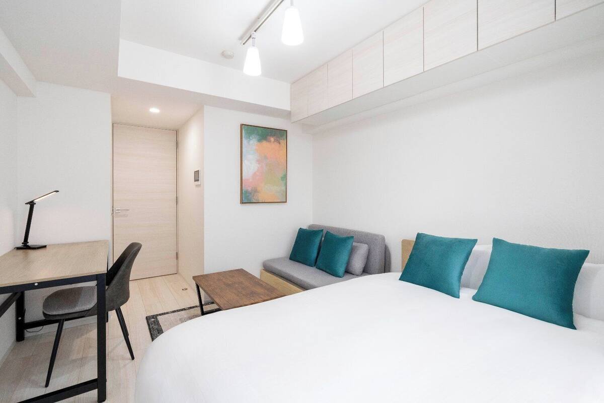 Ein modernes Schlafzimmer mit einem großen Bett, einem Schreibtisch und einer Couch.