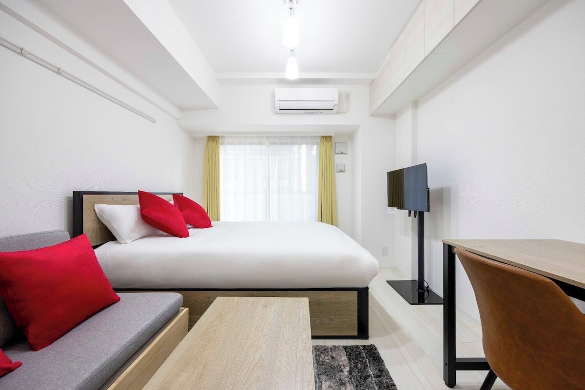 Ein Hotelzimmer mit Bett, Schreibtisch, Fernseher und Sofa.
