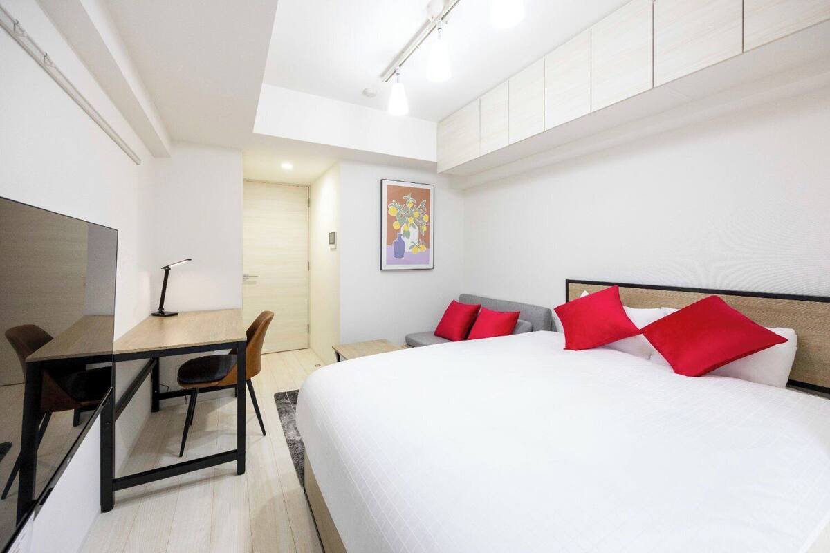 Ein modernes Hotelzimmer mit einem großen Bett, einem Schreibtisch und einem Stuhl.