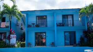 Un hotel con piscina, balconi e palme.