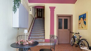 A staircase leading to an upper floor, a table with chairs, a bicycle, and a door with a window. - Erz-Apartment Holiday Flat with Free Minibar and Wi-Fi (Jahnsdorf/Erzgeb)