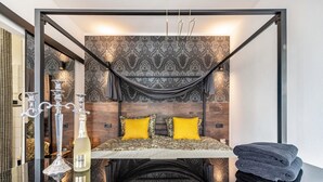 A modern bedroom with a bed, decorative pillows, a chandelier, and a mirror. - Erz-Apartment Holiday Flat with Free Minibar and Wi-Fi (Jahnsdorf/Erzgeb)
