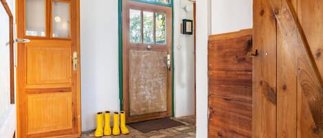 A wooden door with a glass panel, a wooden door with a green frame, and a wooden door with a diagonal design.