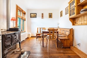 Une cuisine avec des meubles de rangement en bois, une cuisinière et une table à manger avec des chaises.