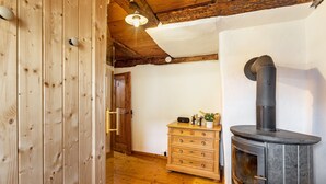 Un interior de madera con chimenea, un aparador de madera y una puerta.