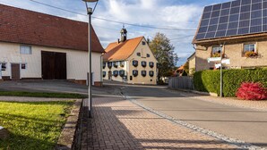 Una calle con arquitectura europea tradicional, un panel solar en una casa y un cielo despejado.