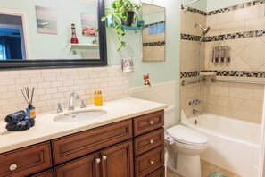 Une salle de bain équipée d’un lavabo, d’un miroir et d’un espace douche.
