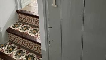 Un escalier orné d’un motif décoratif en carreaux et une porte sur laquelle est inscrit le mot « LOFT ».