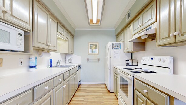 A kitchen with white cabinets, a microwave, a refrigerator, and a stove.