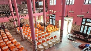 Un grand hall doté de rangées de chaises, d’un escalier et d’un espace détente avec des canapés.
