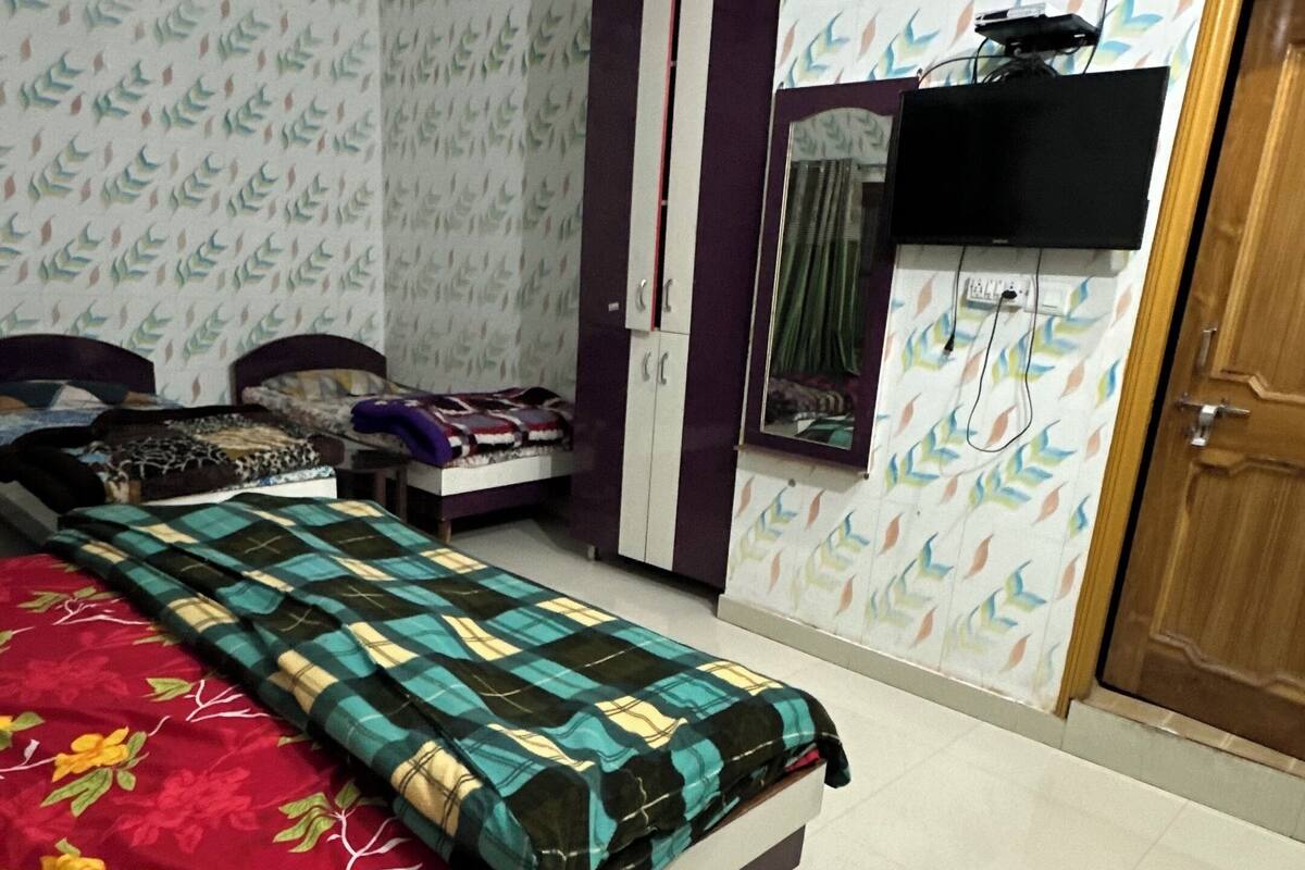 A bedroom with a bed, wardrobe, and a television.