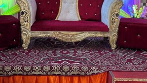 Un canapé luxueux, agrémenté de motifs dorés raffinés, posé sur un tapis à motifs.