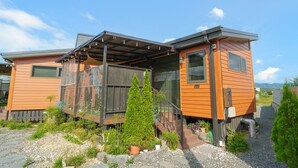 A modern house with a covered porch, a small garden, and a view of the mountains. - Gyeongju Daol Dokchae Pension (Gyeongju)