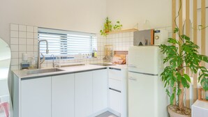 A modern kitchen with white cabinets, a built-in sink, and a refrigerator. - Gyeongju Daol Dokchae Pension (Gyeongju)
