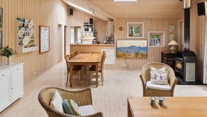 A wooden interior with a dining area, kitchen, and a fireplace. - "Tyyne" - 250m from the sea by Interhome (Sjællands Odde)