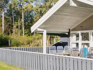Enjoy dining and socializing in this shaded patio area with a grill and comfortable seating for four.