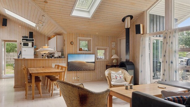 A modern interior with a wooden ceiling, a dining area, a kitchen, and a fireplace. - "Tyyne" - 250m from the sea by Interhome (Sjællands Odde)