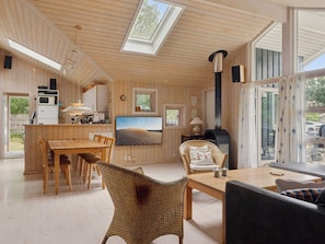 A modern interior with a wooden ceiling, a dining area, a kitchen, and a fireplace. - "Tyyne" - 250m from the sea by Interhome (Sjællands Odde)