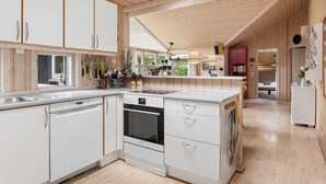 A modern kitchen with white cabinetry, a dishwasher, and a built-in oven. - "Tyyne" - 250m from the sea by Interhome (Sjællands Odde)