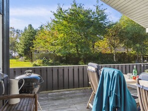 Enjoy al fresco dining in a backyard setting with a grill, chair, and table.