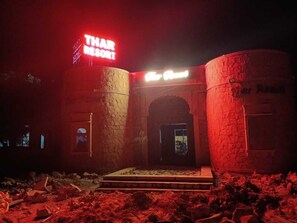 A building with a sign reading "THAR RESORT" and "The Court" illuminated in red neon lights. - Thar Resort Jaisalmer (Jaisalmer)