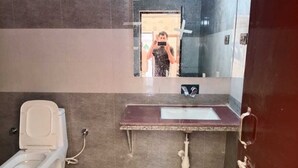 Een badkamer met toilet, wastafel en spiegel.