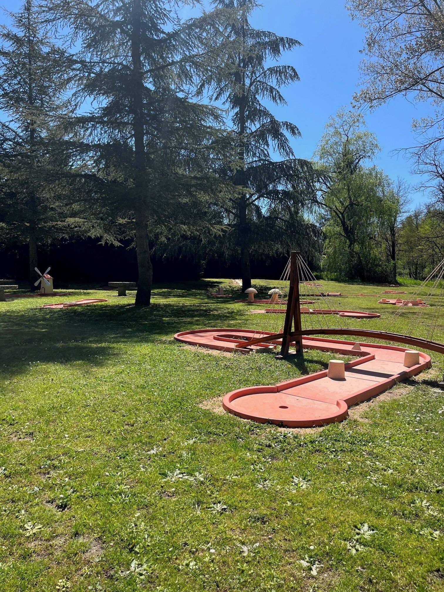 A park with a windmill, a swing set, and a circular play area.