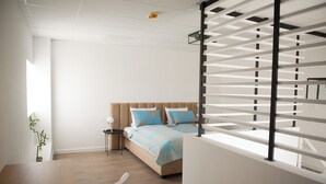 A modern bedroom with a bed, bedside table, and a window with blinds. - FRIENDS RESIDENCE (Timisoara)