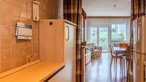 Une cuisine compacte dotée d’un plan de travail en bois, d’un réfrigérateur et d’un coin repas avec une table et des chaises.