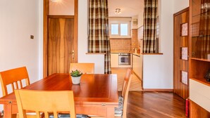 Un coin repas avec une table en bois, des chaises et une plante en pot.