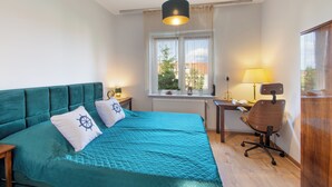 Un dormitorio con cama, escritorio y silla.