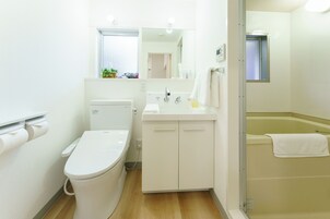A modern bathroom with a toilet, sink, and bathtub.