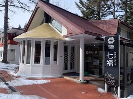 A hotel entrance with a covered waiting area and a signboard displaying the hotel's name.