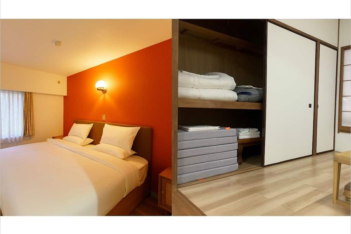 A hotel room with a bed, a nightstand, a wardrobe, and a wall-mounted light.