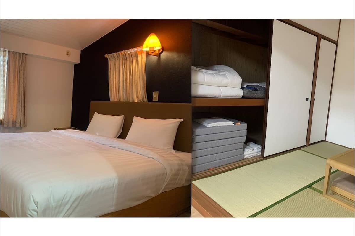 A hotel room with a bed, a nightstand, a lamp, a wardrobe, and a futon bed.