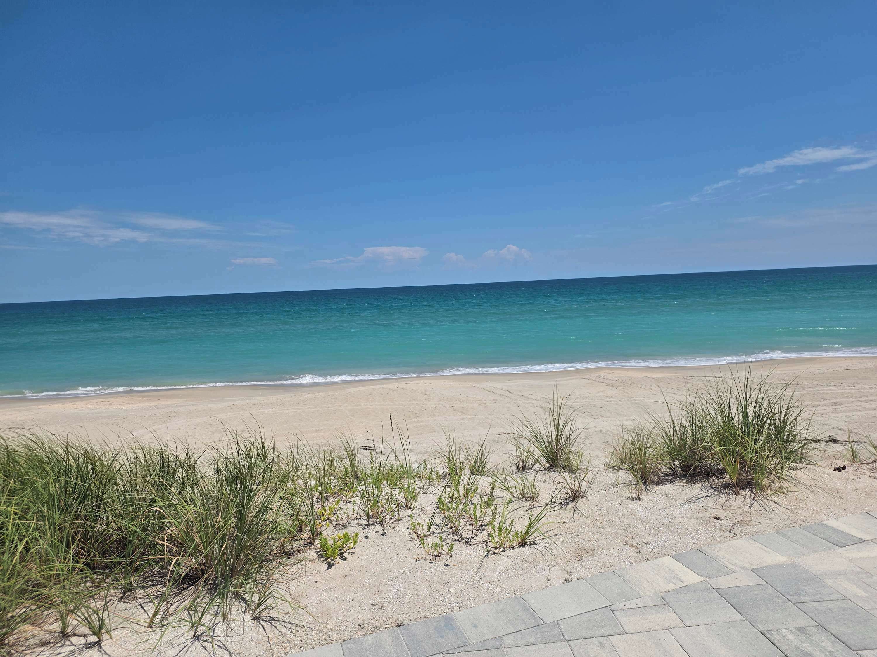 A beach with a clear sky and calm sea.