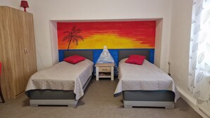 A bedroom with two beds, a nightstand, and a colorful sunset mural on the wall. - Modern apartment Peter in Bärenstein for 2 persons (Bärenstein)