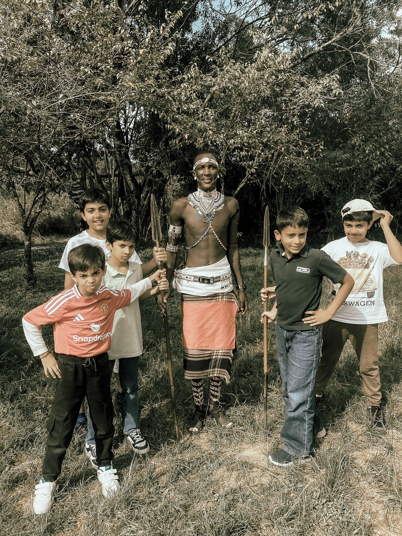 A group of people outdoors with trees in the background.