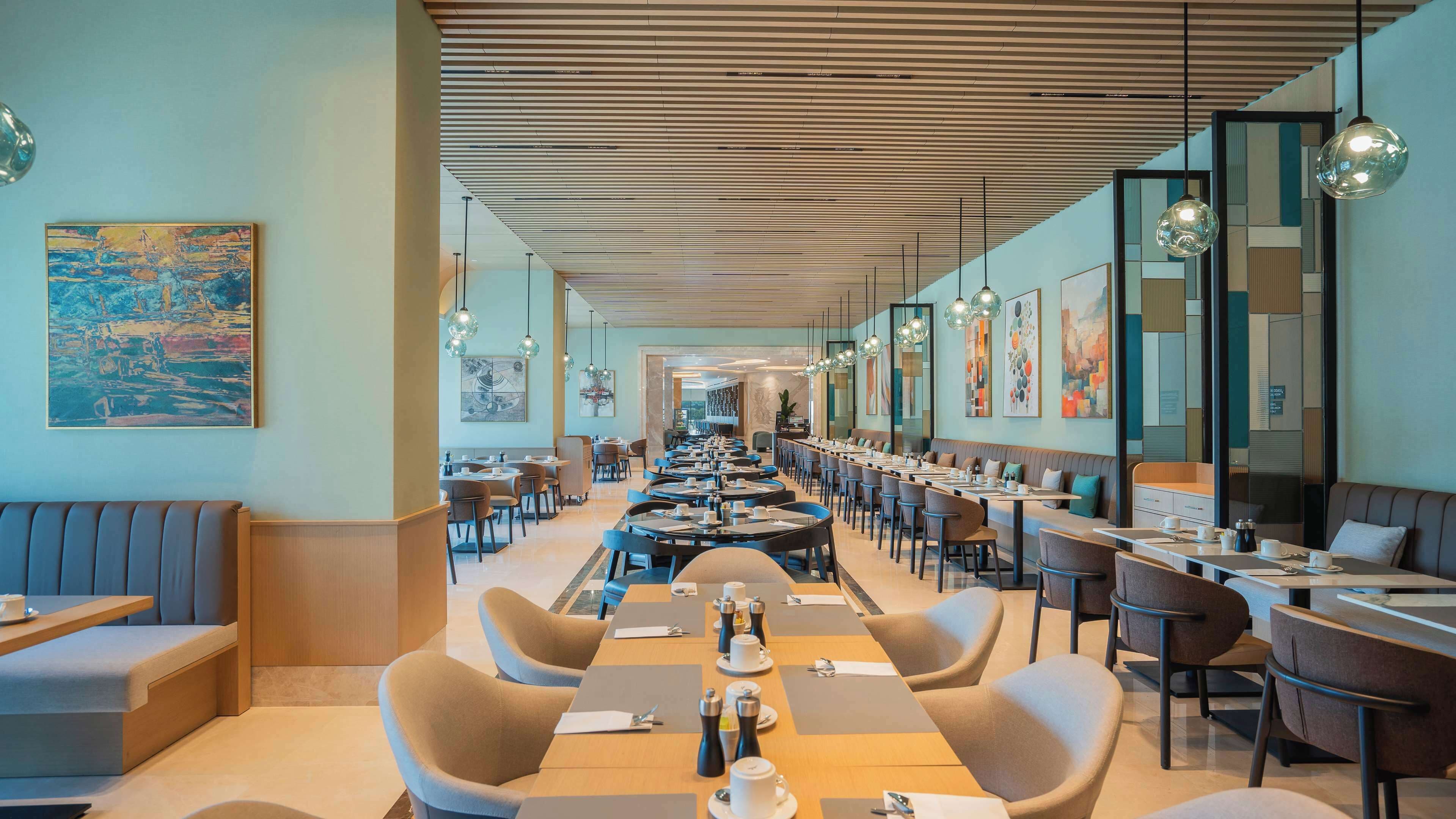 A modern dining area with long tables, comfortable seating, and contemporary decor.