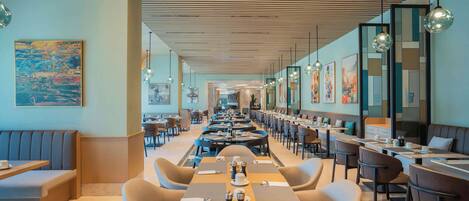A modern dining area with long tables, comfortable seating, and contemporary decor.
